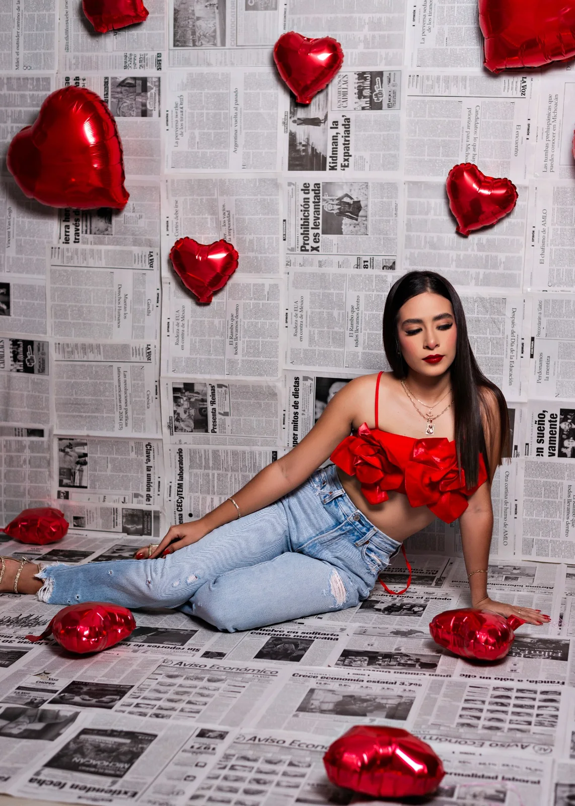 Retrato casual de mujer en escenario de periódicos y globos rojos.